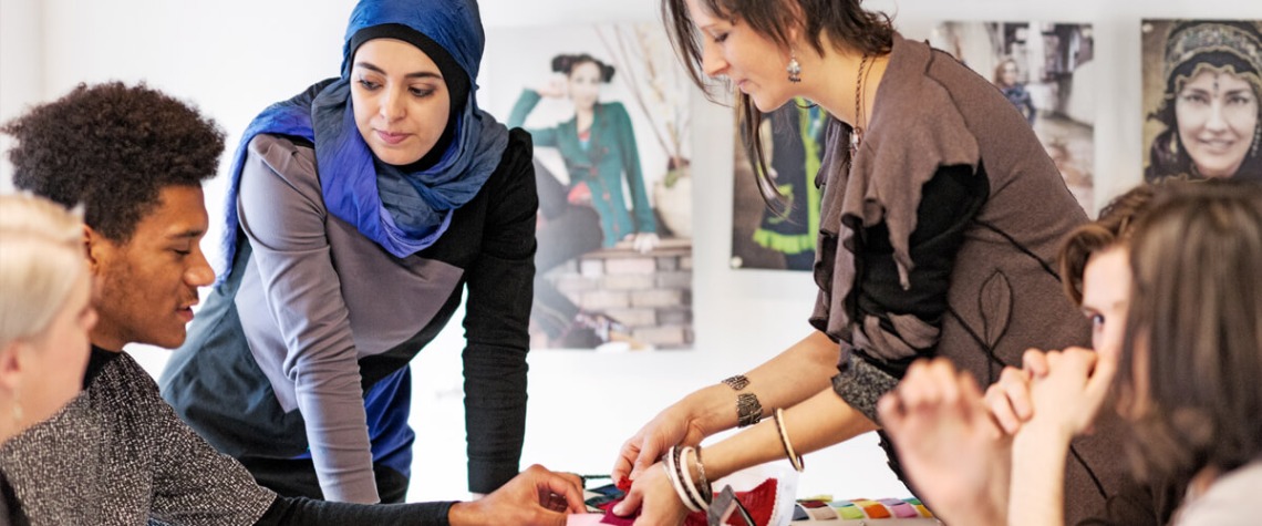 group of students discussing fabric swatches